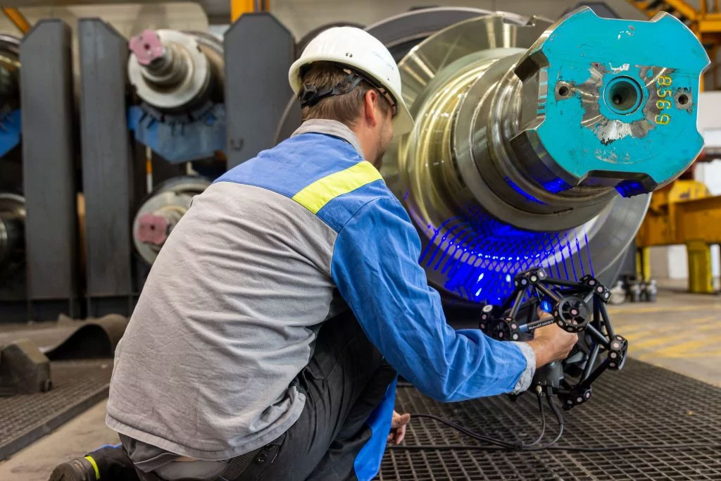 an engineer performs a scan of a shiny shaft with the MetrasCAN 3D scanner directly on the shop floor