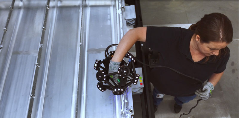 View from above of an employee using the MetraSCAN 3D scanner to inspect a car battery tray