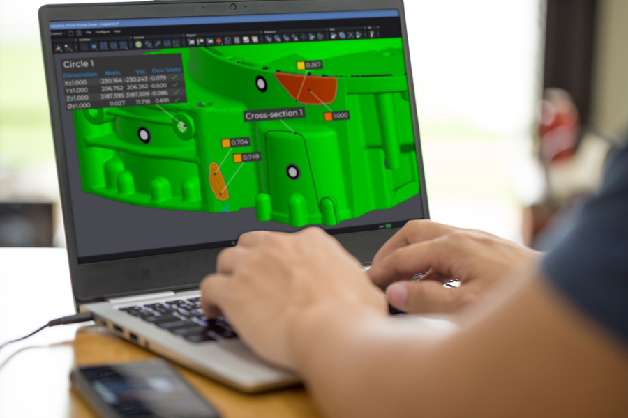 Funcionário trabalhando em um laptop exibindo a peça no módulo de inspeção do Creaform Metrology Suite